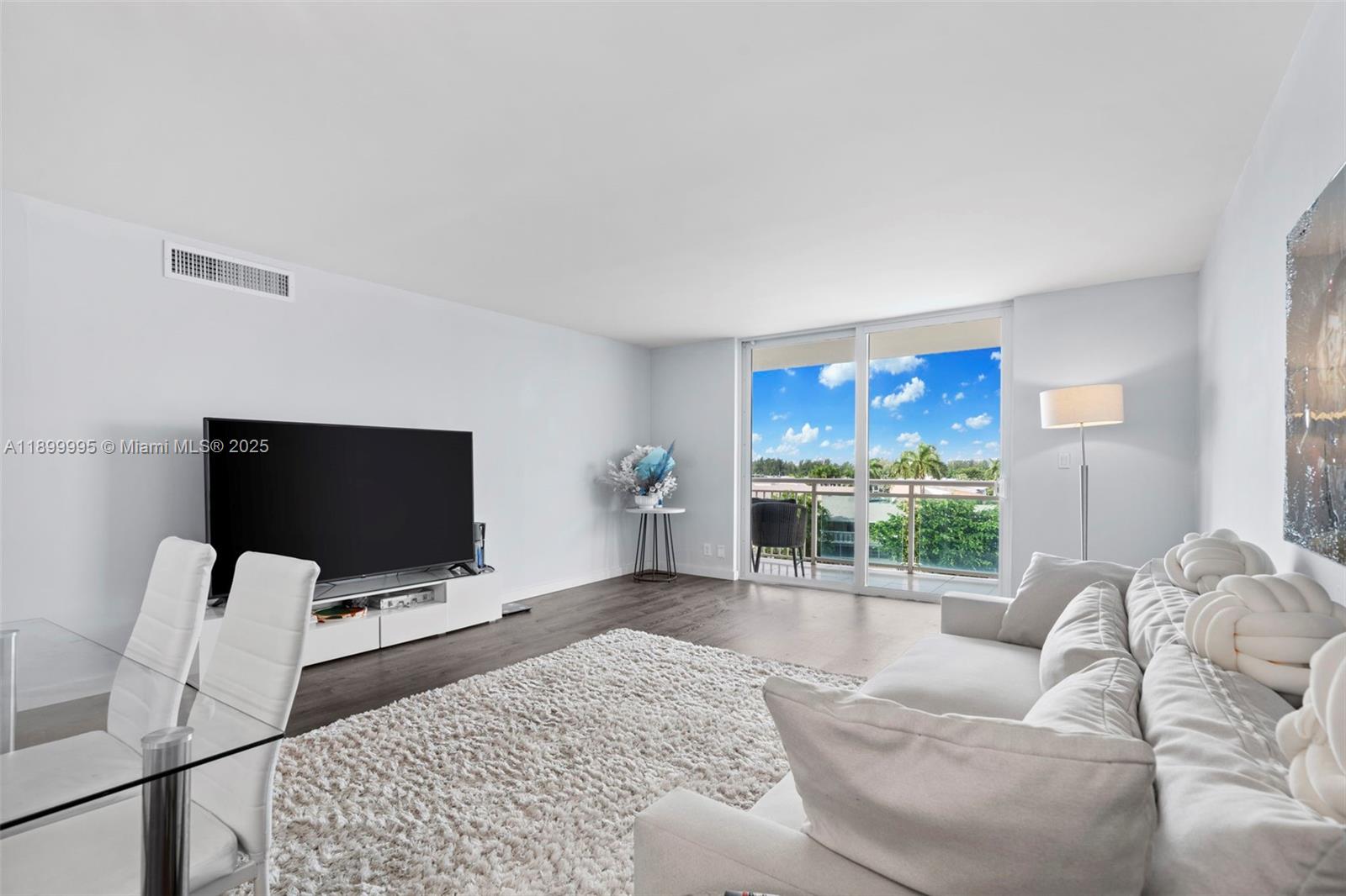 437 Golden Isles Drive, Unit 5J Hallandale Beach, FL 33009 - Photo 8 of 34 a living room with furniture and a flat screen tv