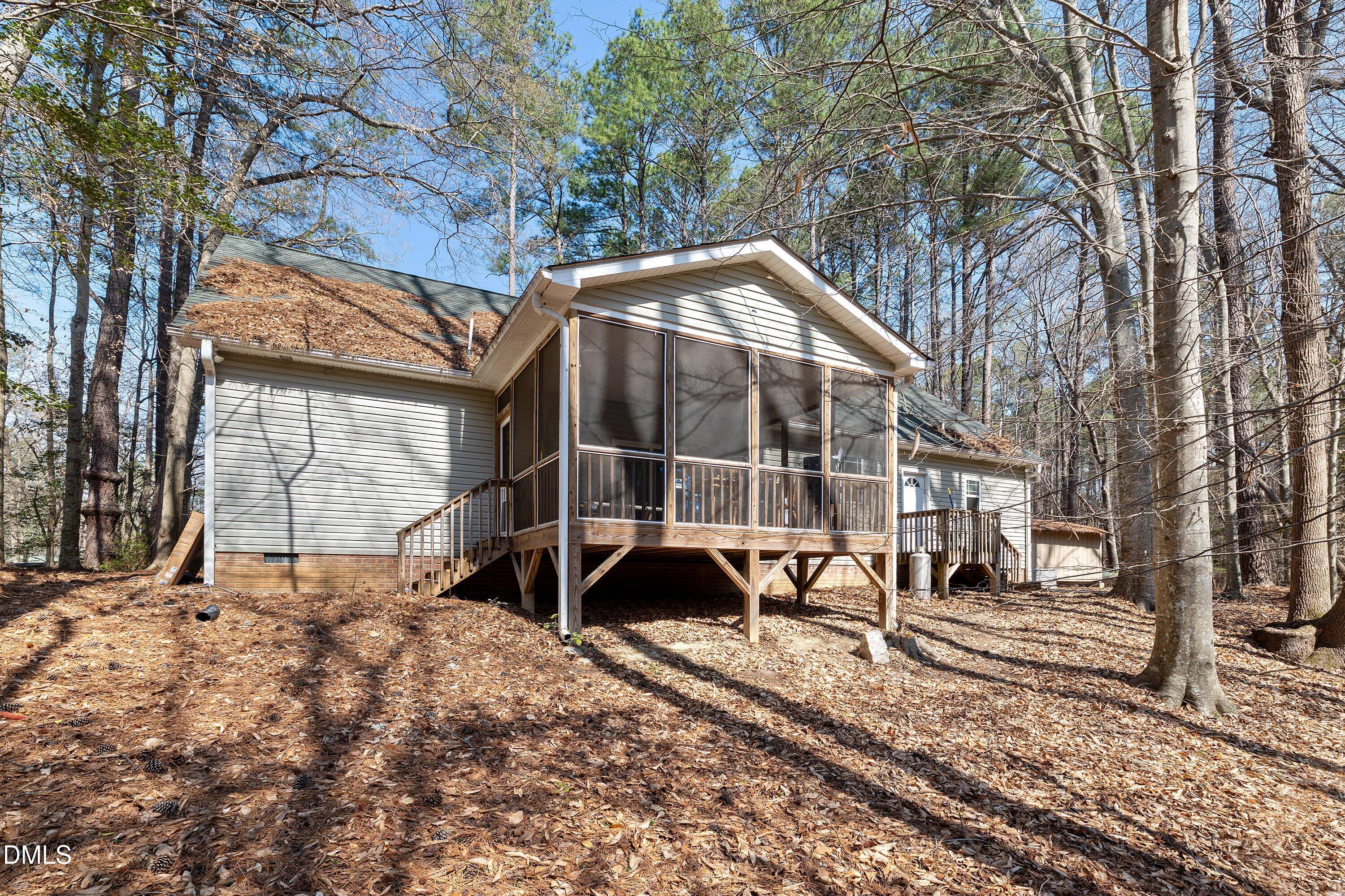 9713 Lake Wheeler Road Raleigh, NC 27603 - Photo 18 of 18 a view of a large house with a yard and lawn chairs under a large tree