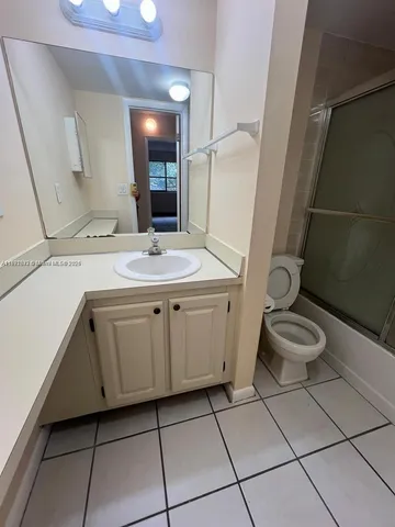 a spacious bathroom with a granite countertop sink a toilet and a mirror