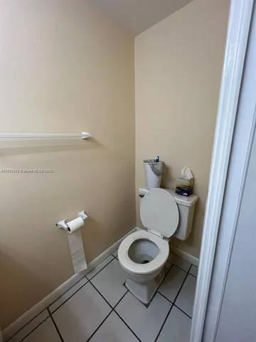 a white toilet sitting next to a white cabinet