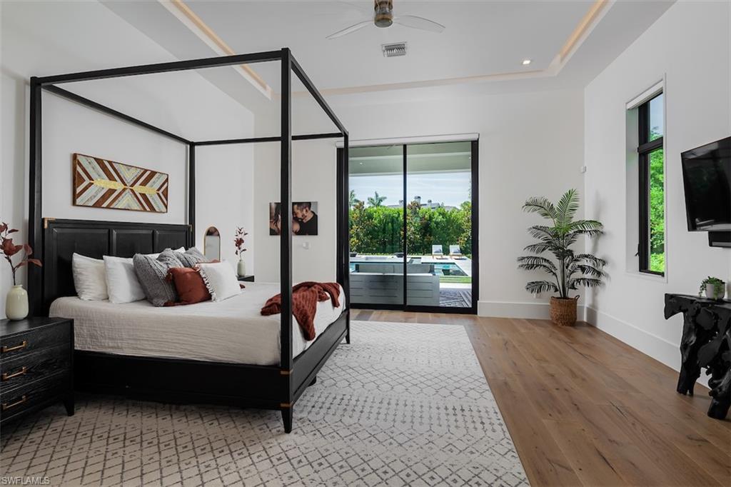 728 Carica Road Naples, FL 34108 - Photo 13 of 26 a bedroom with furniture and a flat screen tv