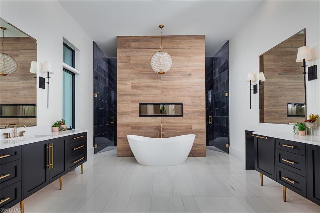728 Carica Road Naples, FL 34108 - Photo 14 of 26 a spacious bathroom with a double vanity sink a mirror a bathtub and window
