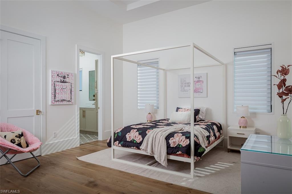 728 Carica Road Naples, FL 34108 - Photo 16 of 26 a bedroom with a bed and wooden floor