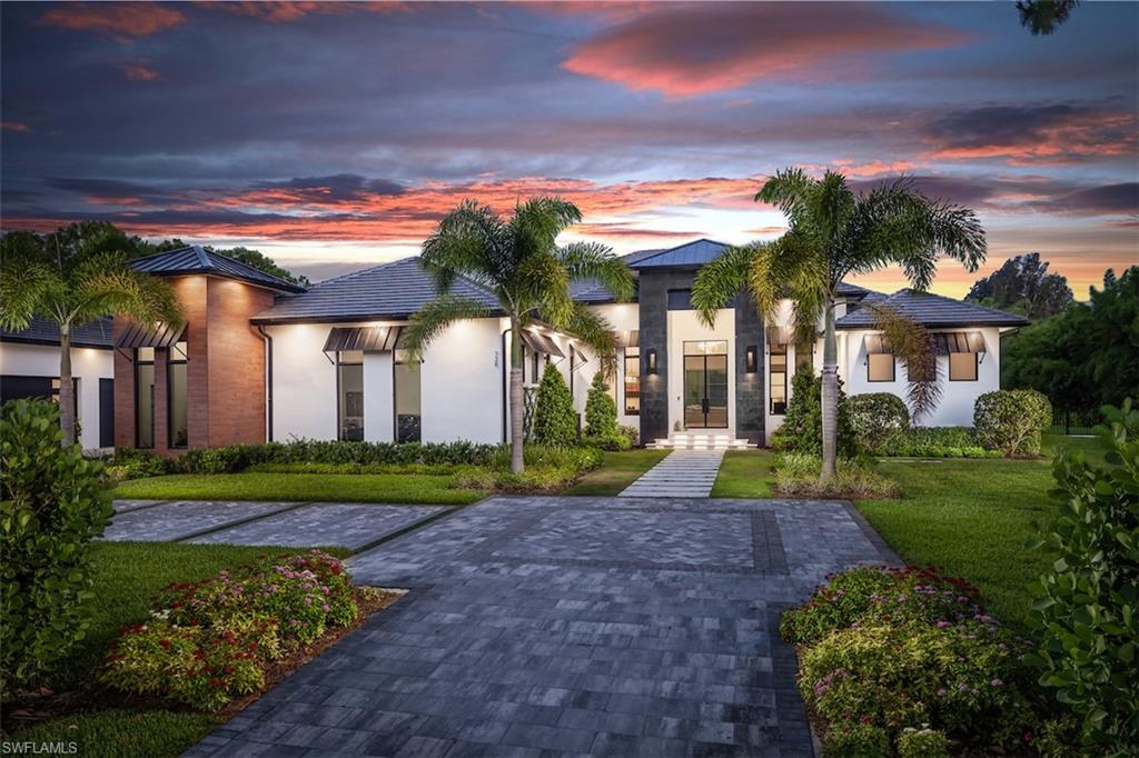 728 Carica Road Naples, FL 34108 - Photo 2 of 26 a view of a house with a yard and potted plants