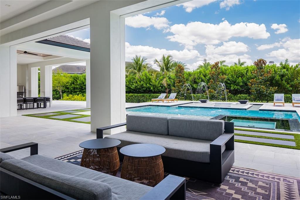 728 Carica Road Naples, FL 34108 - Photo 9 of 26 a living room with furniture and a floor to ceiling window