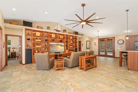 a living room with furniture a ceiling fan and a window