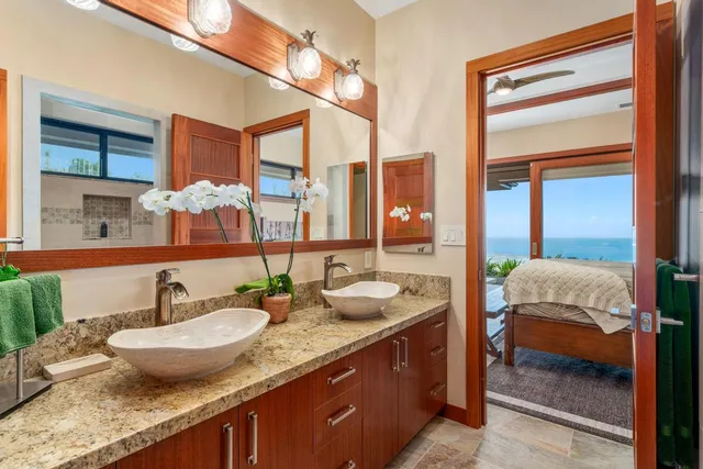 a bed sitting in a spacious bedroom next to a window