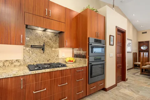 a kitchen with stainless steel appliances granite countertop a refrigerator and a stove