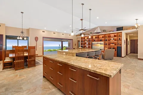 a large kitchen with stainless steel appliances kitchen island granite countertop a table and chairs