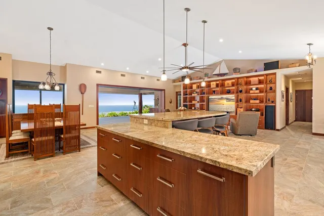 a large kitchen with stainless steel appliances kitchen island granite countertop a table and chairs