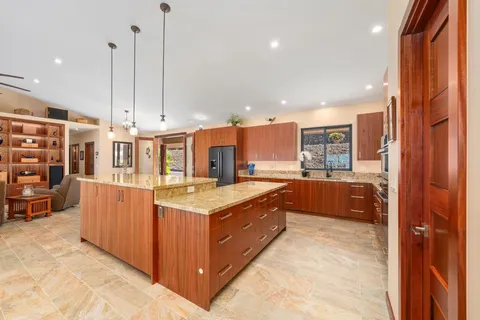 a kitchen with stainless steel appliances granite countertop a stove a sink and a refrigerator