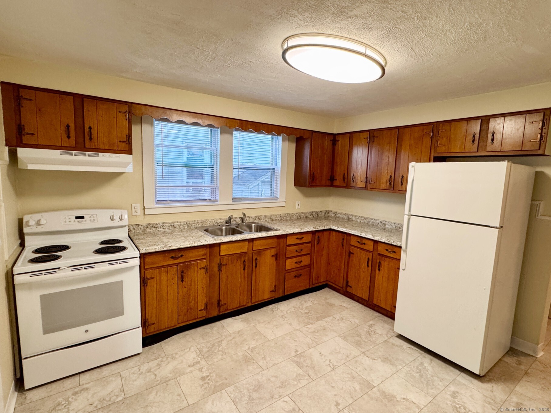 132 North Elm Street, Unit U1 Torrington, CT 06790 - Photo 2 of 12 a kitchen with a white cabinets and white appliances