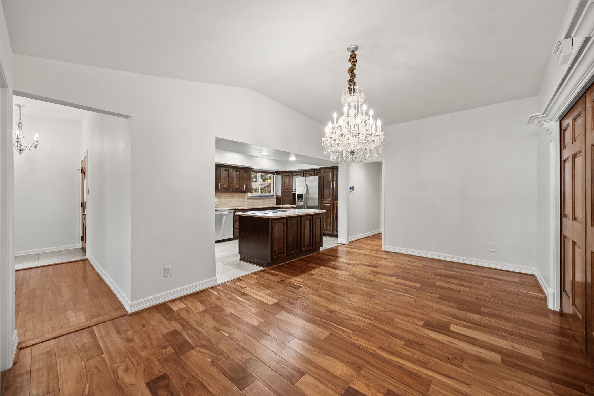 10310 Mayfield Road Houston, TX 77043 - Photo 13 of 49 Living room flows into dining room with wood floors and beautiful chandelier
