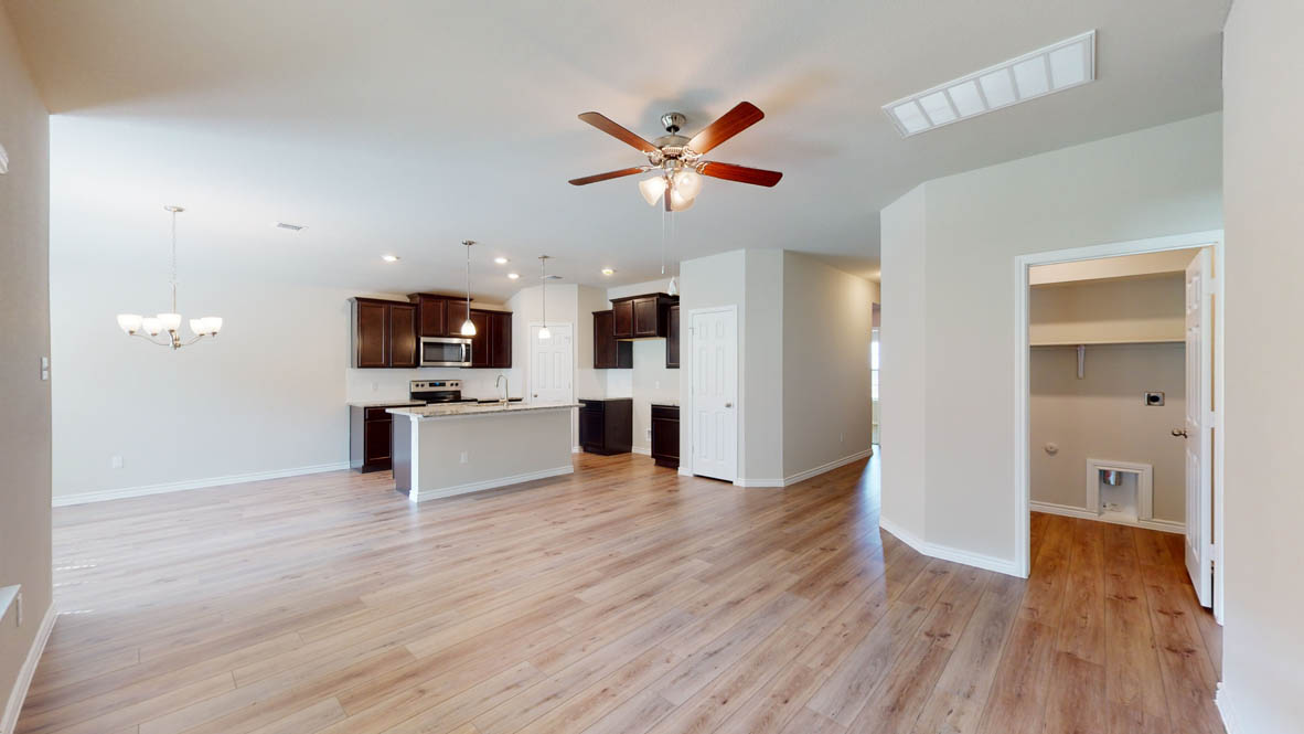 429 Creekfall Road Burnet, TX 78611 - Photo 12 of 28 A spacious, open-concept living area with lustrous hardwood-style flooring seamlessly connects to a contemporary kitchen.