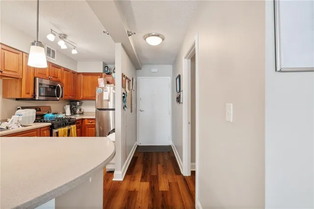 a view of a kitchen with kitchen island a sink stainless steel appliances and cabinets