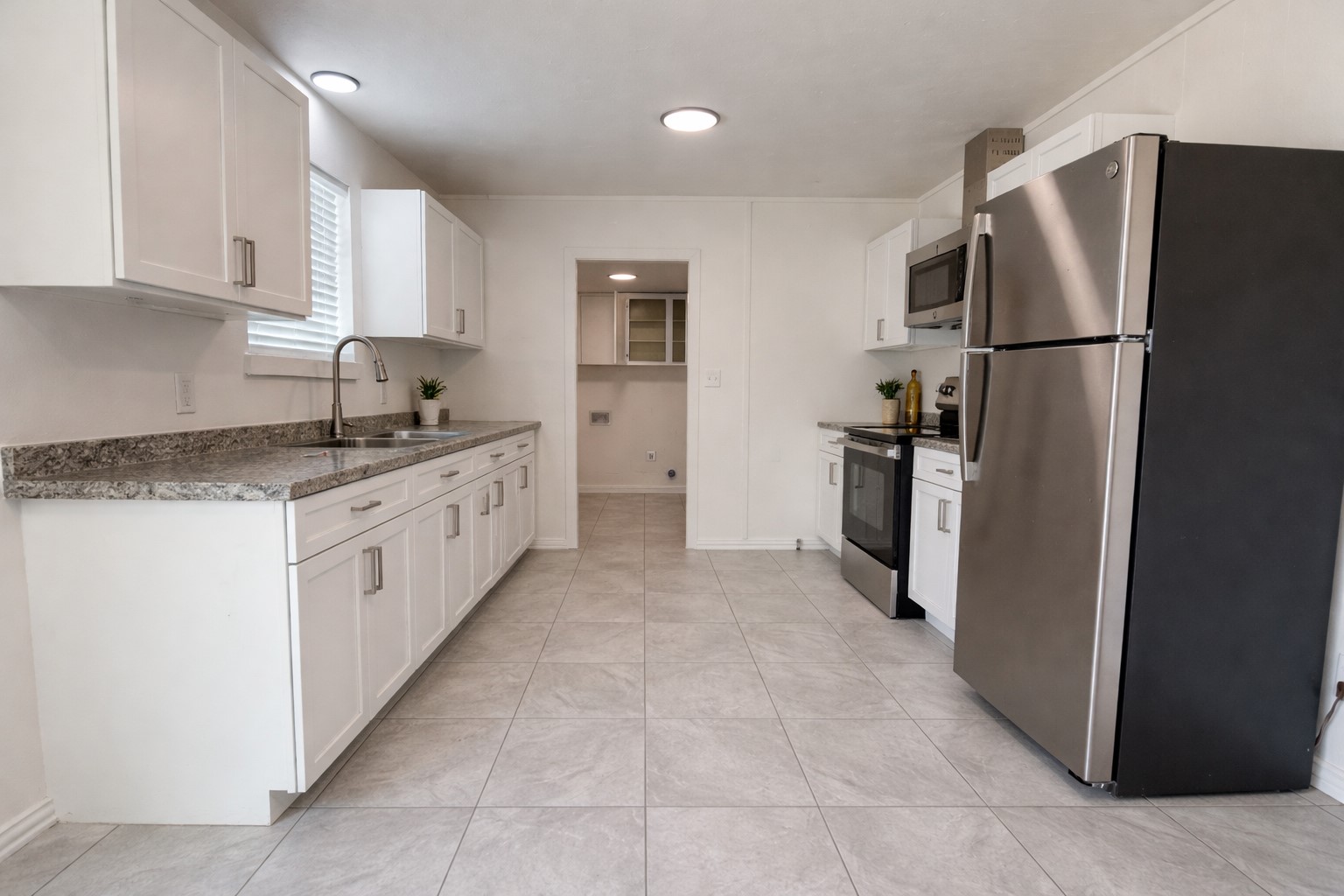 209 West Alfred Street El Campo, TX 77437 - Photo 5 of 15 a kitchen with stainless steel appliances granite countertop a refrigerator and a stove