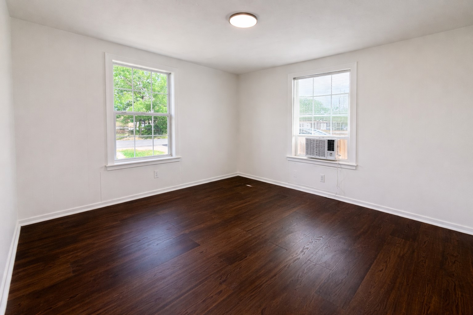 209 West Alfred Street El Campo, TX 77437 - Photo 6 of 15 an empty room with wooden floor and windows