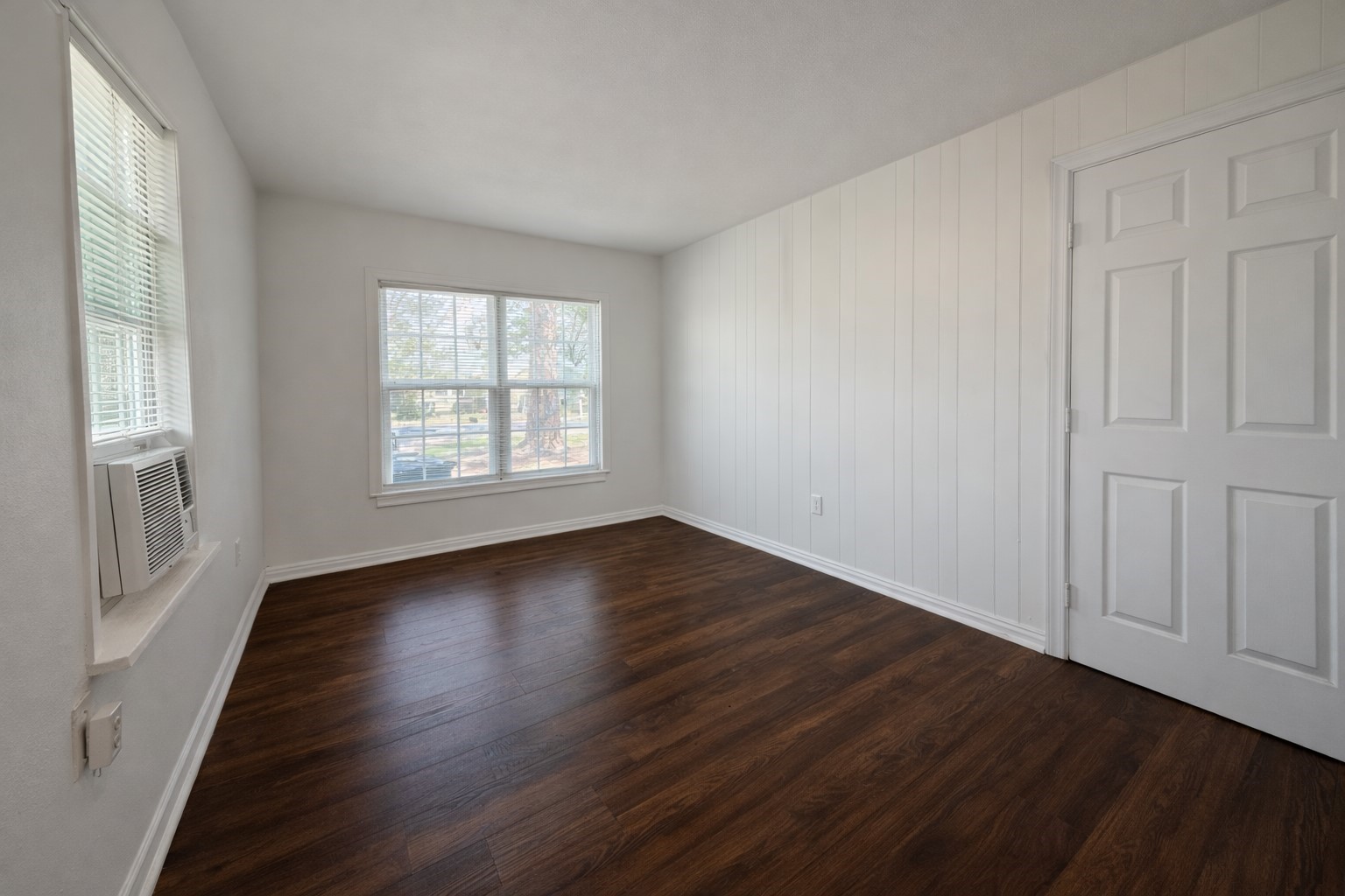 209 West Alfred Street El Campo, TX 77437 - Photo 8 of 15 an empty room with wooden floor and windows