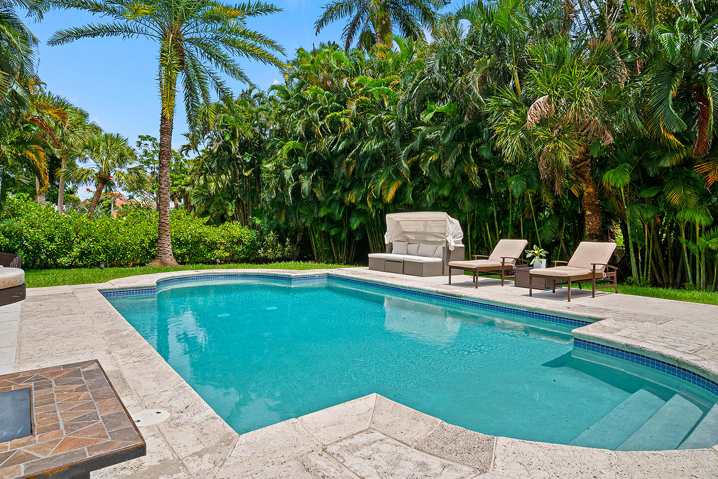 4206 Washington Road West Palm Beach, FL 33405 - Photo 42 of 50 a view of a swimming pool with a lounge chair and trees in the background