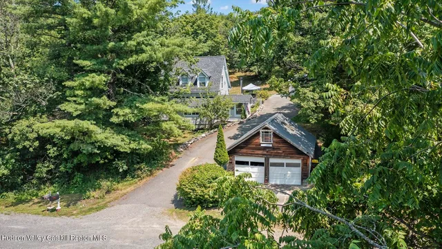 an aerial view of a house with a yard and large trees