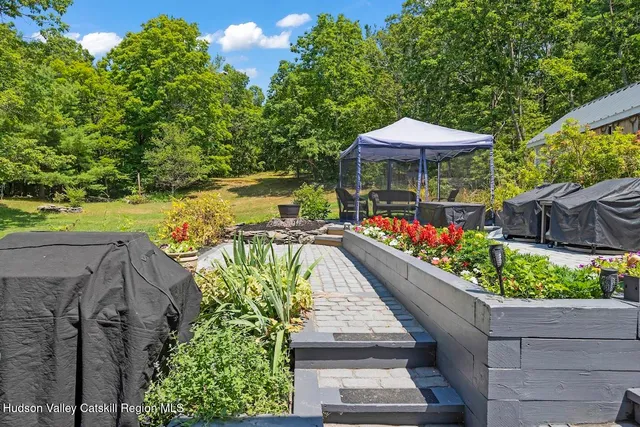 a view of a chairs and table under an umbrella with potted plants