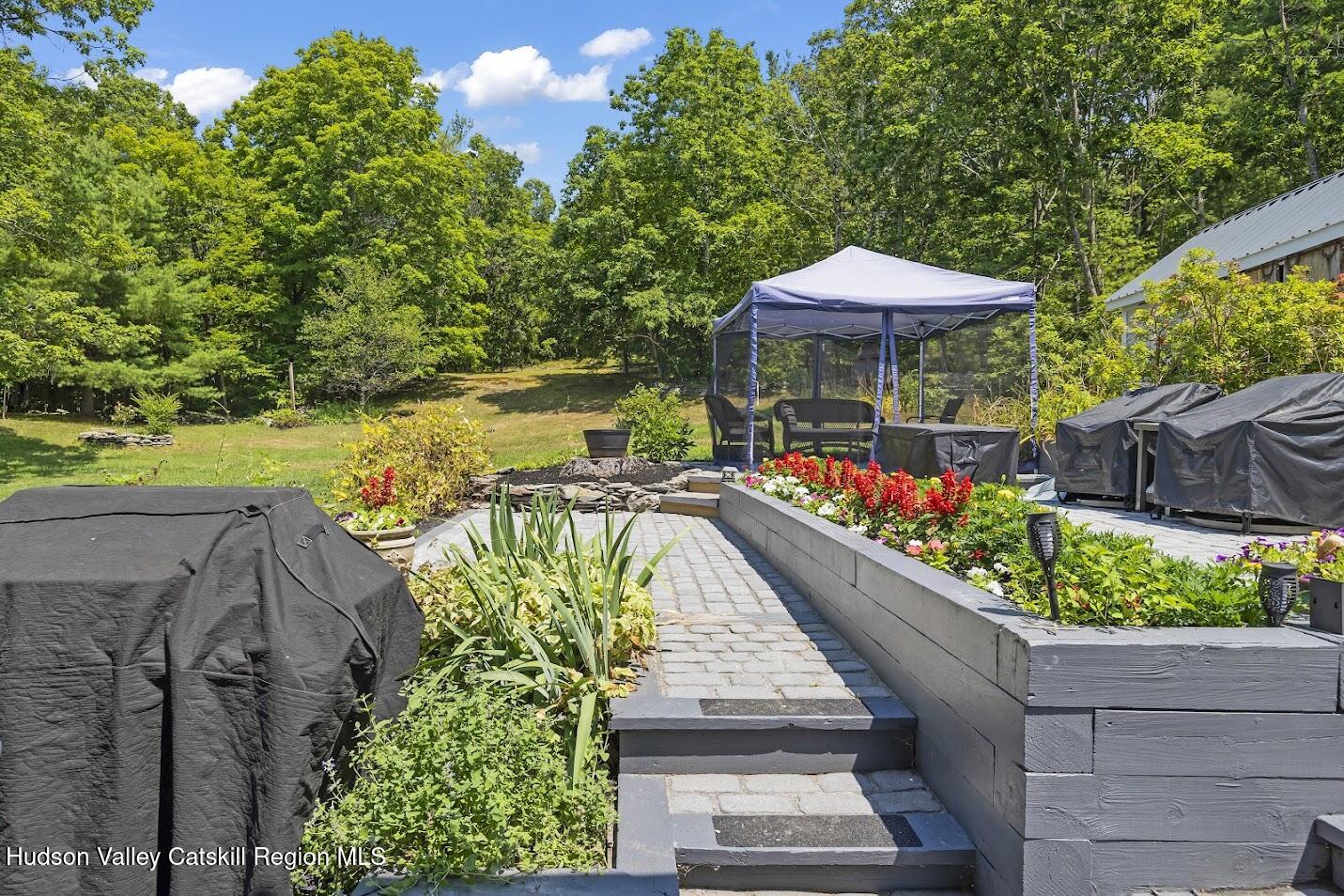 4 Greely Road Craryville, NY 12521 - Photo 5 of 37 a view of a chairs and table under an umbrella with potted plants