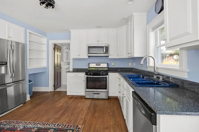 a kitchen with granite countertop a sink stove and refrigerator