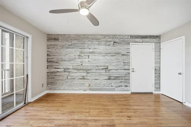 a view of a room with wooden floor cabinets and a kitchen space