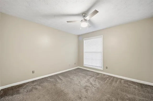an empty room with chandelier fan