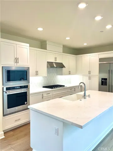 a kitchen with kitchen island a sink stainless steel appliances and cabinets