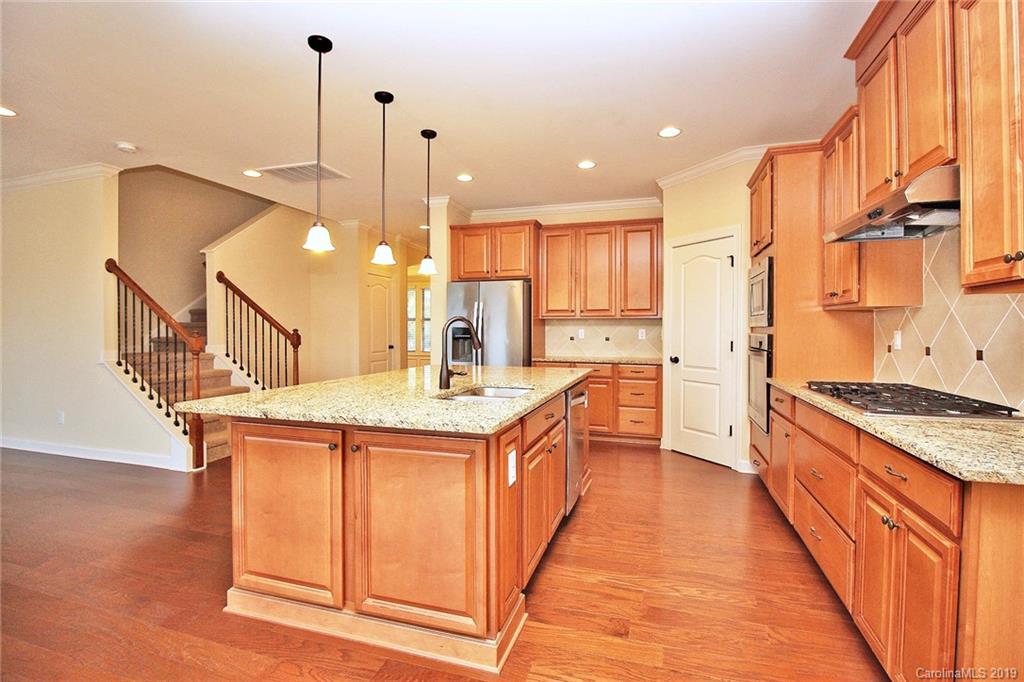 1314 Cilantro Court Tega Cay, SC 29708 - Photo 12 of 48 a kitchen with stainless steel appliances granite countertop a stove a sink and a wooden floors