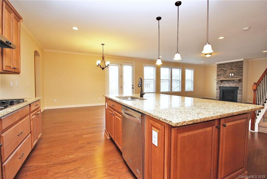1314 Cilantro Court Tega Cay, SC 29708 - Photo 13 of 48 a kitchen with stainless steel appliances granite countertop a sink a stove and a wooden floor
