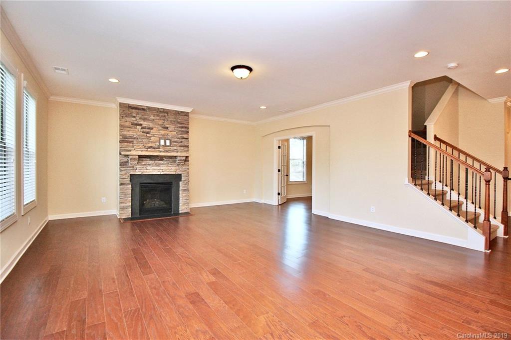 1314 Cilantro Court Tega Cay, SC 29708 - Photo 18 of 48 a view of an empty room with wooden floor and a fireplace