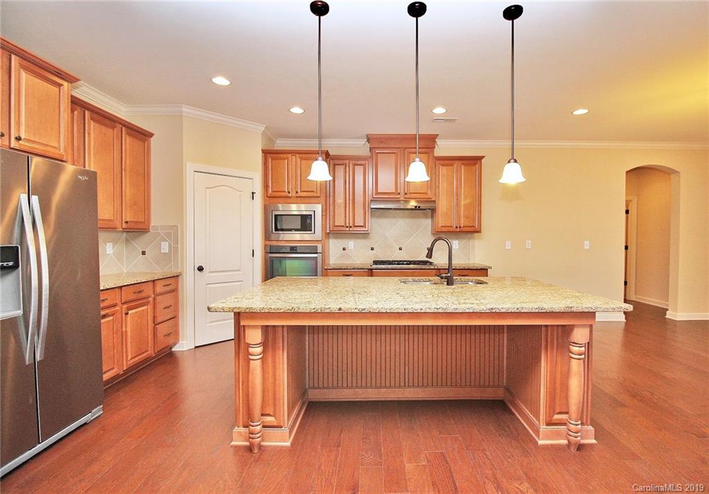 1314 Cilantro Court Tega Cay, SC 29708 - Photo 23 of 48 a kitchen with stainless steel appliances granite countertop a sink a refrigerator and a wooden floor
