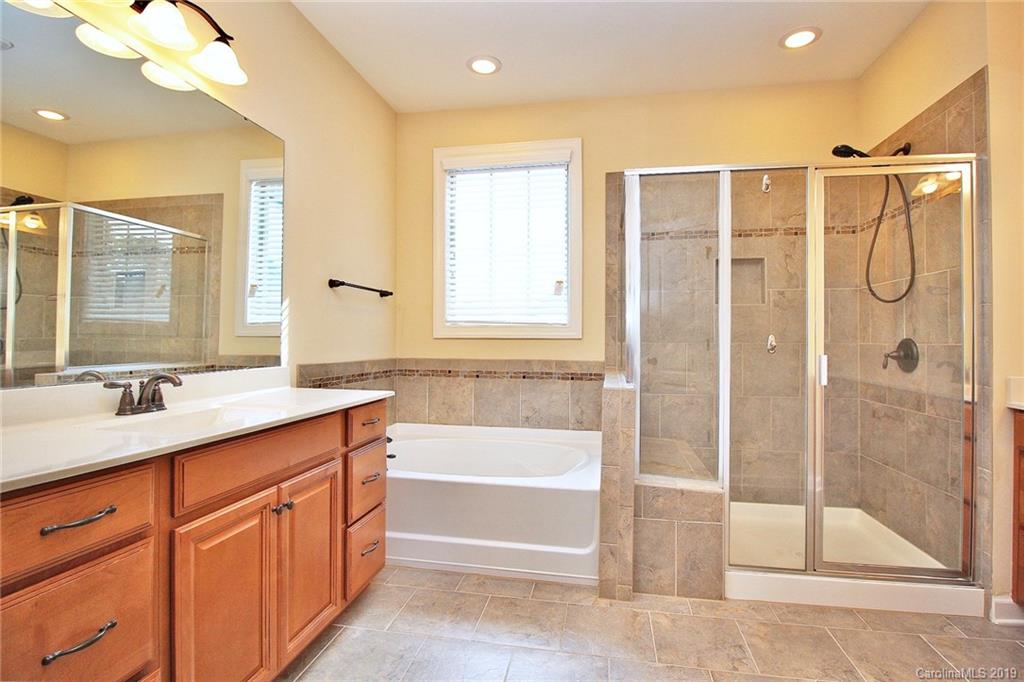 1314 Cilantro Court Tega Cay, SC 29708 - Photo 29 of 48 a bathroom with a shower sink vanity and mirror