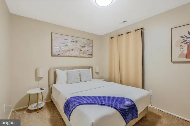 a bedroom with a bed and a painting on the wall