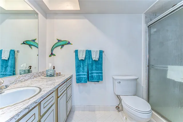 a bathroom with a granite countertop toilet sink and mirror