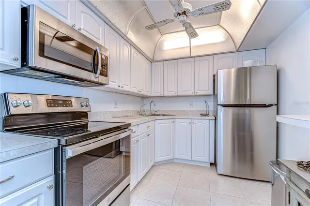 a kitchen with stainless steel appliances granite countertop a refrigerator a stove and a sink