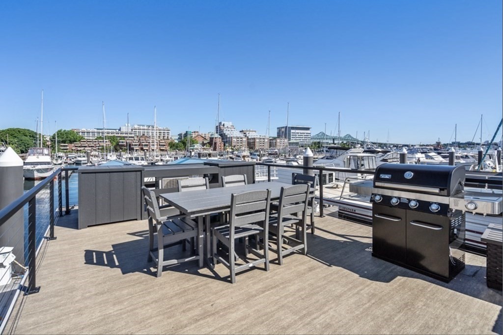 1 Pier 8, Unit BH Boston, MA 02129 - Photo 14 of 18 a view of a terrace with wooden table and chairs