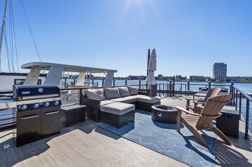 1 Pier 8, Unit BH Boston, MA 02129 - Photo 15 of 18 a living room with furniture a flat screen tv and kitchen view