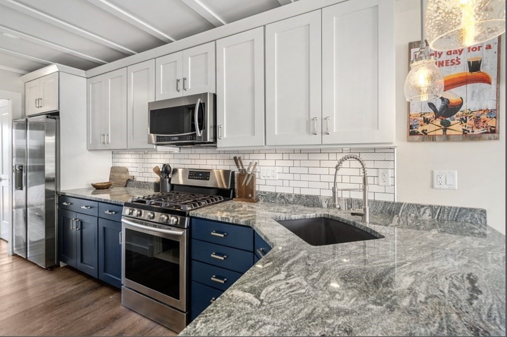 1 Pier 8, Unit BH Boston, MA 02129 - Photo 6 of 18 a kitchen with stainless steel appliances granite countertop a stove a sink and a microwave