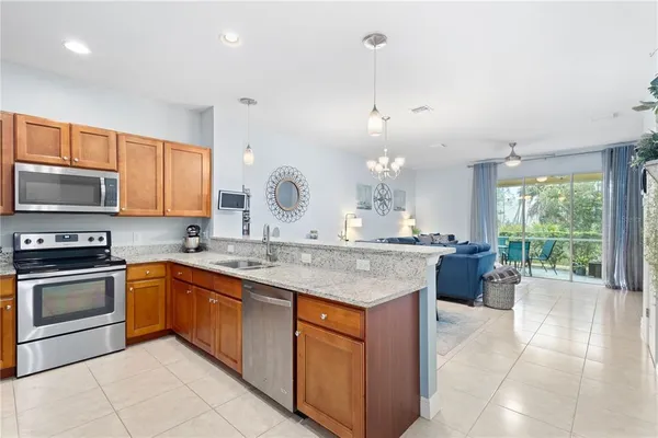 a kitchen with stainless steel appliances granite countertop a refrigerator stove microwave and sink