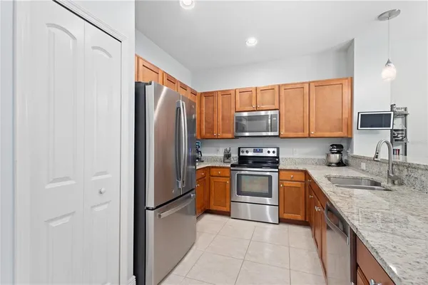 a kitchen with stainless steel appliances granite countertop a refrigerator and a stove top oven