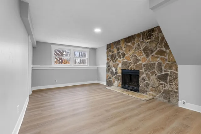 an empty room with windows and fireplace