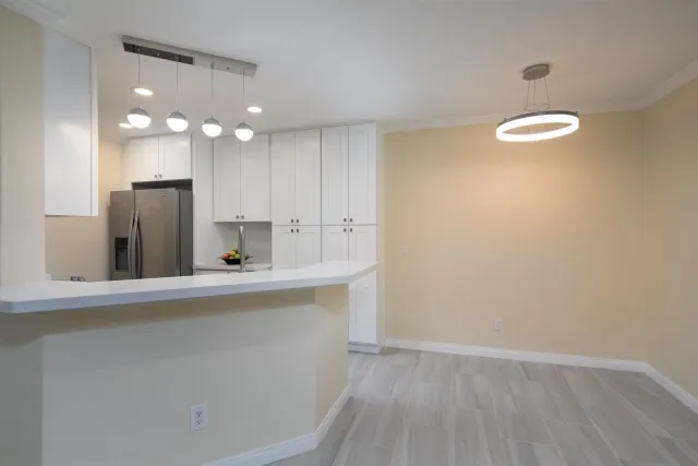 a view of a kitchen with a sink and a refrigerator