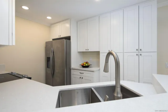 a kitchen with a refrigerator sink and cabinets