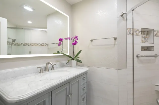 a bathroom with a granite countertop sink and a mirror