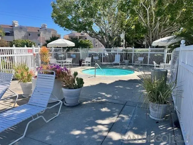 a view of a chair and tables under an umbrella in backyard
