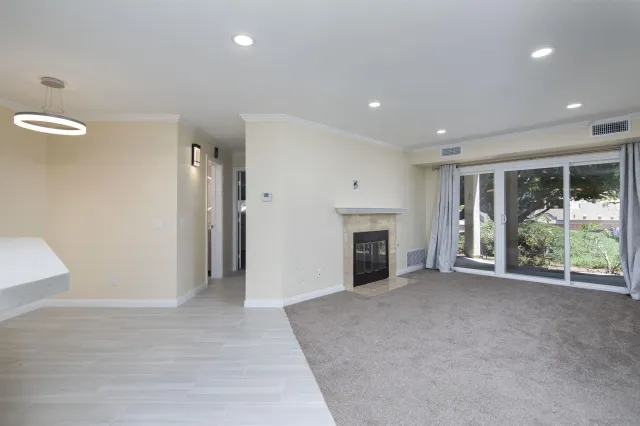 a view of an empty room with a fireplace and a window