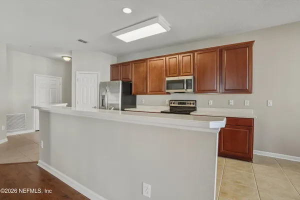 a kitchen with stainless steel appliances granite countertop a refrigerator sink and stove